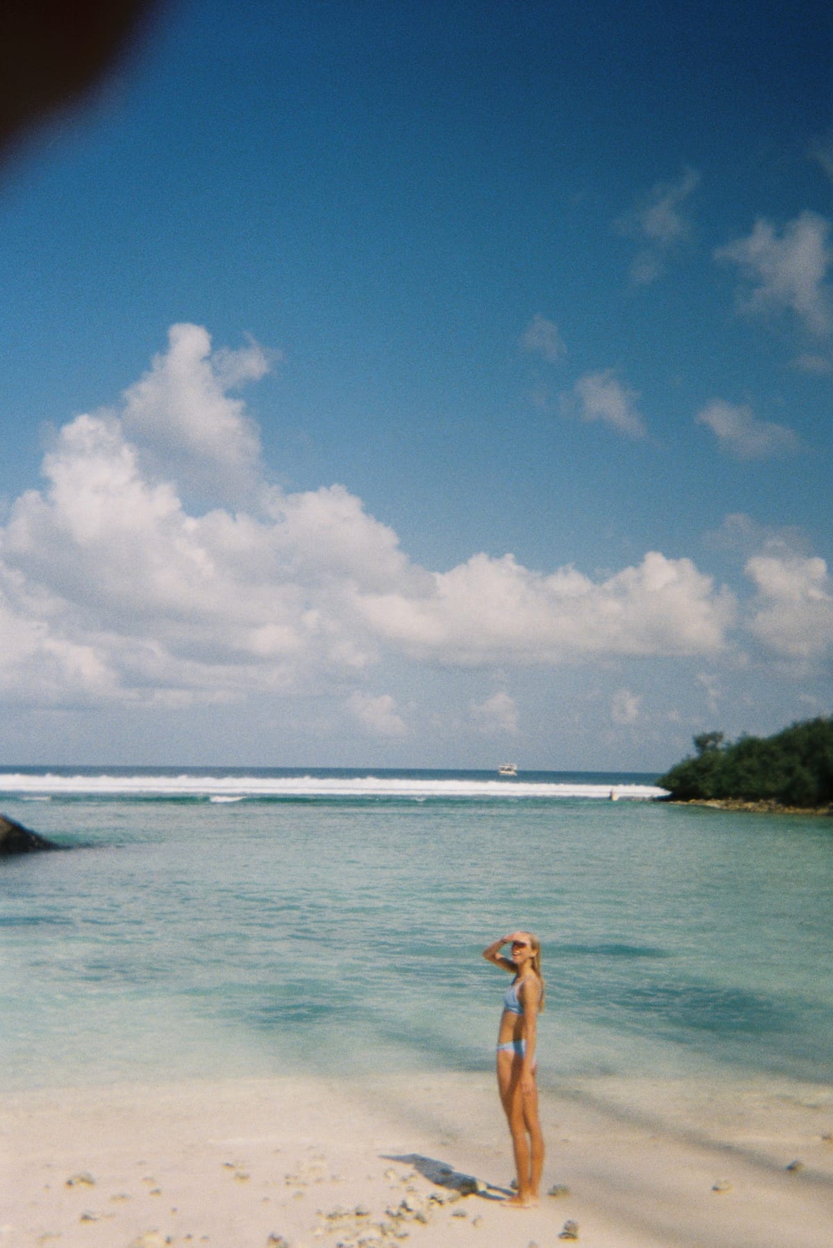 Miek standing in shallow turquoise water at the beach